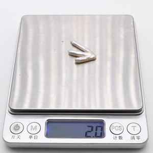 Vista macro di una perla barocca da 2,0g su una bilancia con riflessi naturali unici