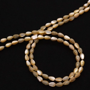 Macro shot of drop-shaped shell beads with champagne luster for DIY jewelry making