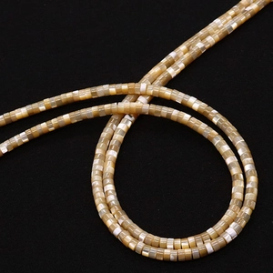 Macro shot of natural shell wheel beads for DIY jewelry with iridescent champagne gloss