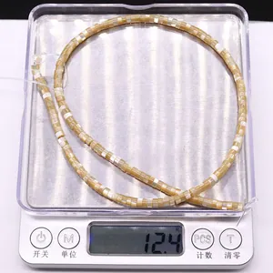Detailed view of natural shell wheel beads weighing 12.4g on a digital scale for DIY