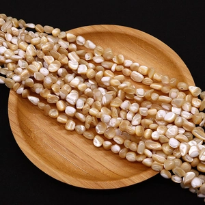 Macro detail of irregular natural shell beads showing iridescent luster for jewelry making