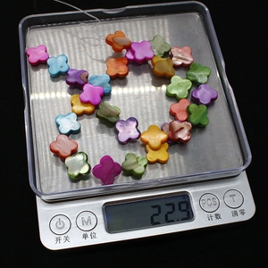 Dettaglio macro di perle colorate a forma di fiore di conchiglia su una bilancia digitale