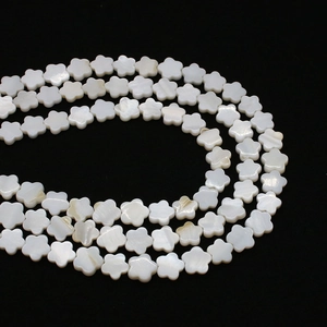 Macro detail of natural white mop shell flower beads with shimmering pearlescent luster