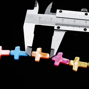 Macro shot showing 13.5mm colorful cross-shaped natural shell beads with calipers
