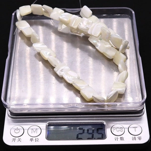 Square shell beads for jewelry making shown on electronic scale for weight verification