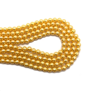 Macro detail van gefacetteerde gouden kralen met metaalglans voor DIY-sieraden