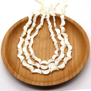 Natürliche weiße Perlmutt-Halbmond-Perlen für DIY-Schmuck in einer Holzschale präsentiert