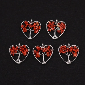 Macro shot of 5 heart-shaped Tree of Life pendants with silver wire and red stones