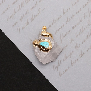 Détail d'un pendentif en pierre naturelle irrégulière avec placage or et incrustation