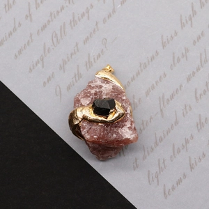 Gros plan d'un pendentif en pierre naturelle violette avec serpent doré et pierre noire