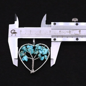 Macro shot of a tree of life heart pendant showing width measurement of 35mm on a caliper