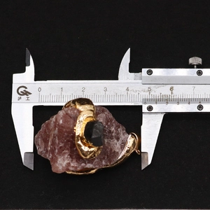 Détail d'un pendentif en citrine mesuré avec un pied à coulisse montrant sa largeur de 4,5 cm