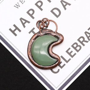 Close-up of crescent moon natural stone pendant with vintage copper plated frame detail