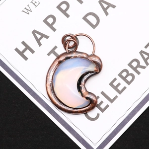 Macro shot of crescent moon opal pendant with antique copper electroplated frame detail