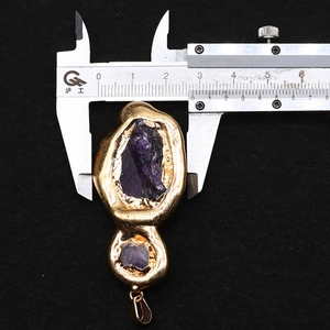 Messen der Breite des rohen lila Amethyst-Kristallanhängers mit einem Messschieber