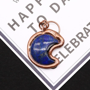 Macro shot of crescent lapis lazuli pendant with vintage copper plated metal frame