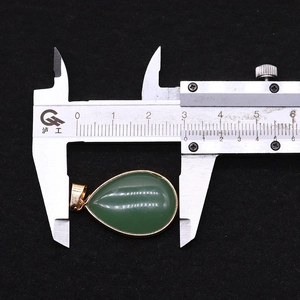 Nahaufnahme des grünen Edelstein-Anhängers mit Messschieber zeigt Länge von 2,7 cm