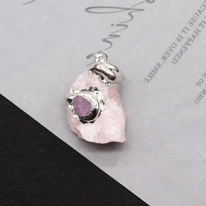 Detail of pink crystal pendant with silver edging and small purple stone accent