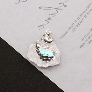 Close-up of a vintage turquoise pendant set on a natural white crystal stone base