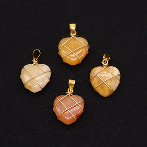 Dettaglio di pendenti in pietra naturale a forma di cuore con filo metallico dorato avvolto