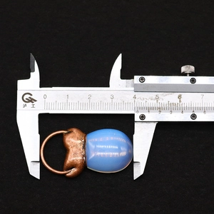 Makroaufnahme des ovalen blauen Steinanhängers mit Metallring, gemessen bei 42 mm