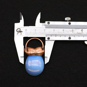 Makroaufnahme eines blauen Steinanhängers mit 25 mm Breite und Metallschlaufe
