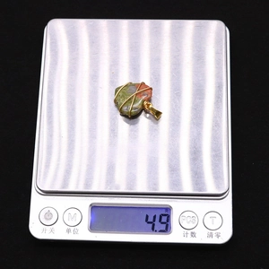 Dettaglio del pendente in pietra Unakite a cuore dal peso di 4,9 g su una bilancia