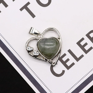 Dettaglio macro del ciondolo a cuore in argento con pietra naturale verde incastonata