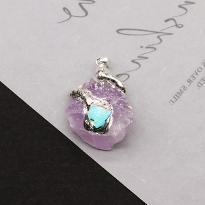 Irregular amethyst crystal pendant with silver metal frame and small turquoise stone