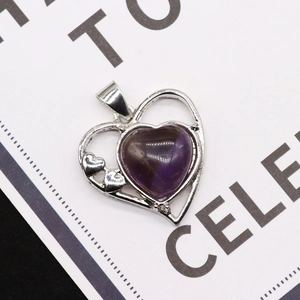 Dettaglio di un ciondolo a cuore in pietra viola con montatura in argento e piccoli cuori