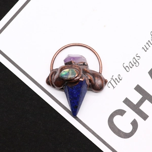 Macro detail van de pijlpunthanger van lapis lazuli en amethist met bronzen zetting