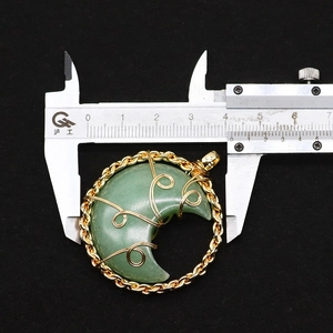Detail view of wire-wrapped moon stone pendant with 41mm measurement on caliper