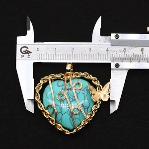 Detailed measurement of a heart turquoise pendant with gold wire butterfly wrap