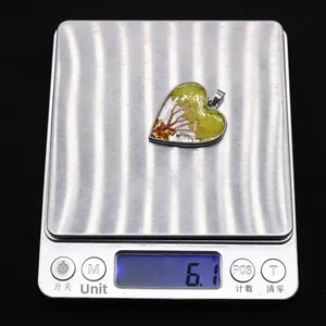 Détail macro du pendentif en forme de cœur sur une balance pesant 6,1 grammes