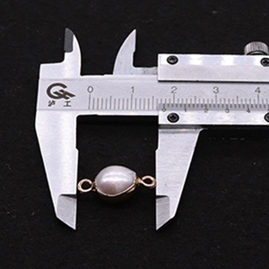 Messschieber zeigt einen 12mm Süßwasserperlen-Verbinder mit goldenen Metallschlaufen