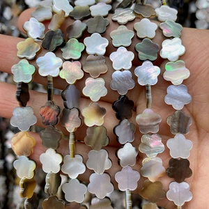Macro detail of plum blossom-shaped natural shell beads with rainbow luster for jewelry