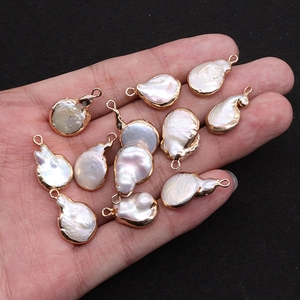 Hand met natuurlijke barokparel hangers met gouden randen voor DIY-sieraden maken