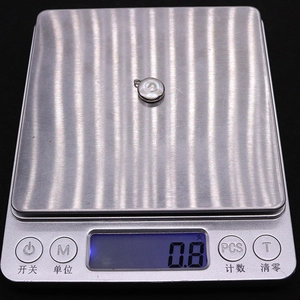 Detail showing natural freshwater pearl pendant on a scale weighing 0.8 grams precisely
