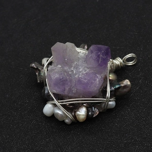 Detaillierter drahtumwickelter Amethyst und unregelmäßige Süßwasserperlen auf Textur
