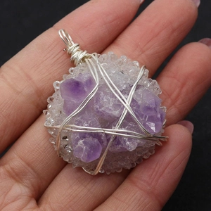 Makroaufnahme von handgefertigtem Amethyst-Anhänger mit silberner Drahtwicklung