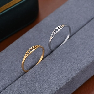 Vista macro de anillos minimalistas con diseños de fases lunares en oro y plata