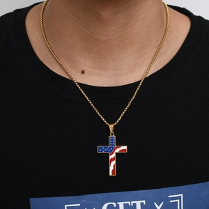 Close-up of gold chain necklace featuring a cross pendant with American flag enamel