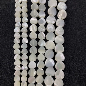 Macro detail of heart-shaped natural white mother of pearl beads in various sizes