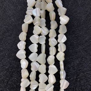 Close-up of heart-shaped natural mother of pearl beads with iridescent white luster