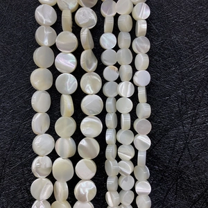 Detailed view of flat white mother of pearl shell beads with natural iridescent luster