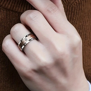 Detail of a dual-tone titanium steel spinner ring with a diamond inlay on a male model