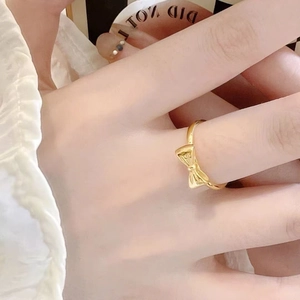Bague élégante avec nœud doré texturé portée au doigt pour un style chic et raffiné