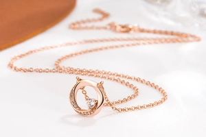 Makroaufnahme der roségoldenen Mobius-Halskette mit Pavé-Diamanten und Hauptstein
