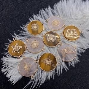 Macro shot of tiger eye stone pendants with gold bee and butterfly filigree charms