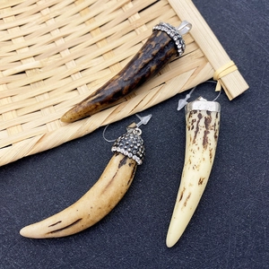 Detailed close-up of retro horn pendants with rhinestone-studded metal caps